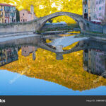 Reflections on the water of the roman bridge in the village of Dolceacqua, Imperia, Italy